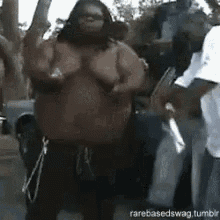 a very fat man with a beard is dancing in a crowd .