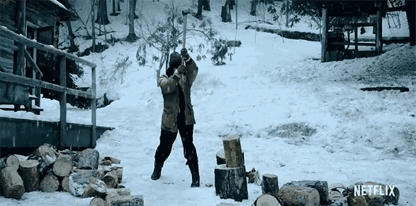 a man chopping logs in the snow with a netflix logo in the background