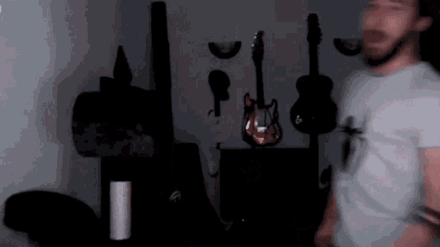 a man in a room with guitars on the wall