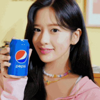 a young woman is holding a can of pepsi