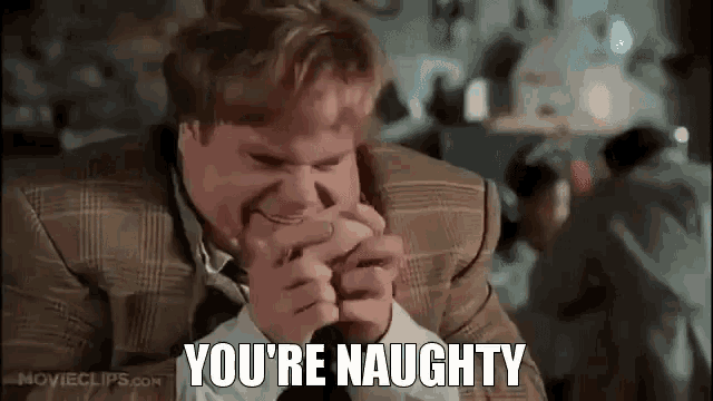 a man in a suit and tie is holding another man 's hand in his mouth and saying you 're naughty .
