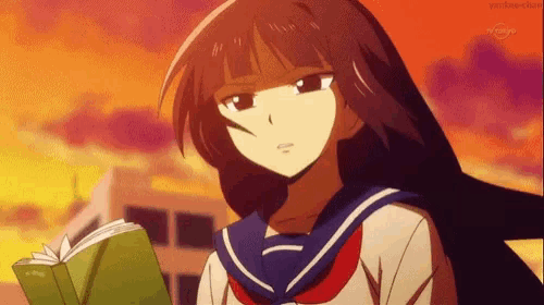 a girl in a school uniform is holding a book in her hands .