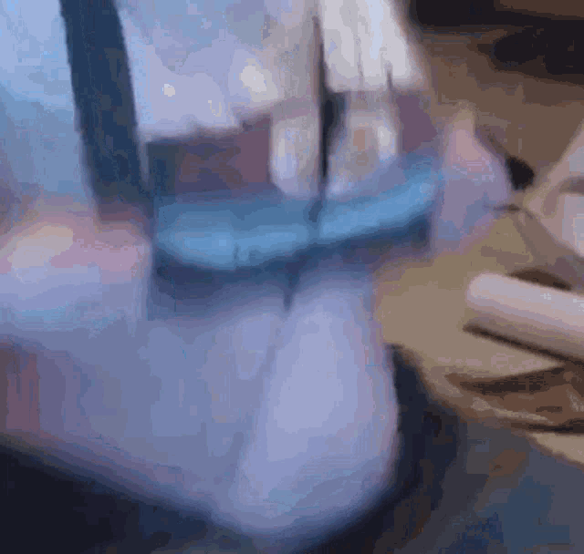 a blurred image of a person 's feet with a blue shirt on
