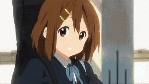 a girl in a school uniform is smiling and holding a guitar case behind her back .