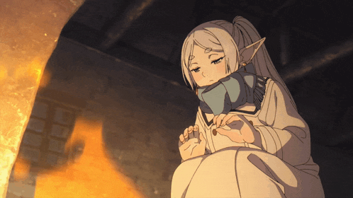 a girl with a scarf around her neck is sitting in front of a fireplace