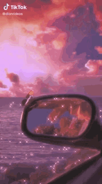 a rear view mirror of a car with a sunset in the background .