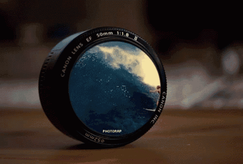 a canon lens has a picture of a man riding a wave