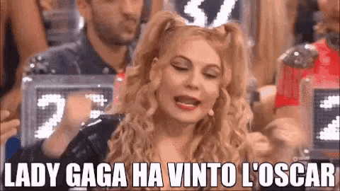 a woman with blonde hair and pigtails is sitting in a crowd of people and says lady gaga ha vinto l ' oscar .