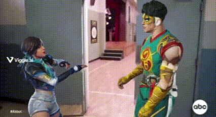 a man in a superhero costume and a woman in a superhero costume are standing next to each other .