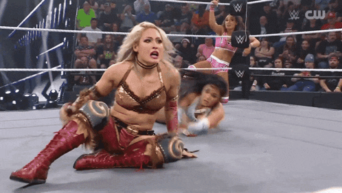 a woman in a wrestling ring with a cw logo