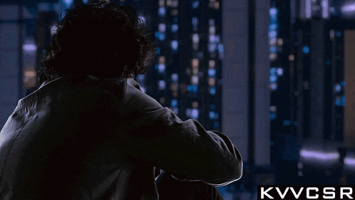 a man is looking out a window with the letters kvvcsr below him