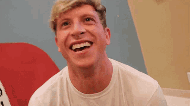 a man in a white shirt is laughing and looking up