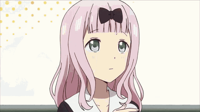 a girl with pink hair and blue eyes is holding something in her hand