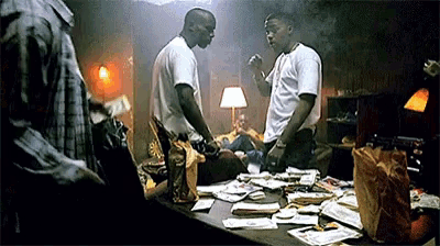 two men are standing in front of a messy table with money on it