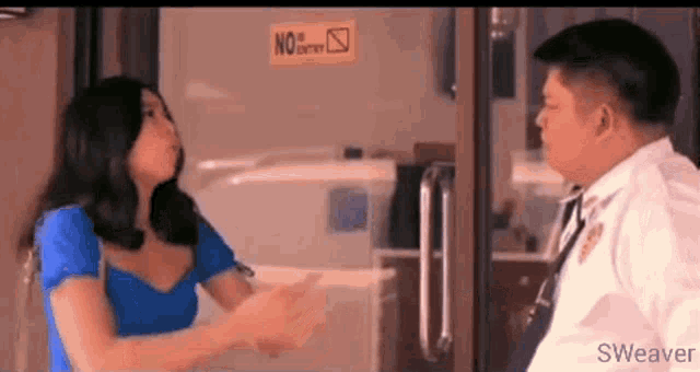 a man and a woman are shaking hands in front of a no smoking sign