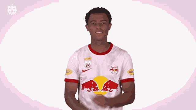 a man is wearing a white jersey with red bulls on the front