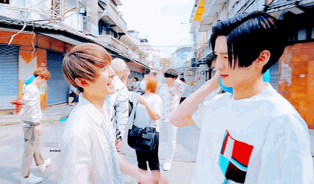 a group of young men are standing in a narrow alleyway