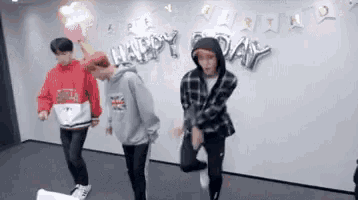 a group of young men are jumping in front of a happy birthday banner