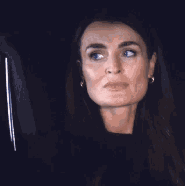 a woman with a surprised look on her face wearing earrings
