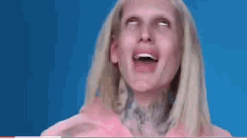 a woman with blonde hair and a tattoo on her neck is making a funny face .