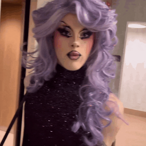 a woman in a purple wig and black top