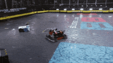 two robots are fighting in a stadium with a sign that says battlebots on it