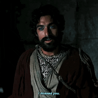 a man with a beard is standing in a dark room and saying `` i missed you . ''