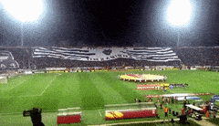 a soccer field with a banner in the stands that says ' i love you ' on it