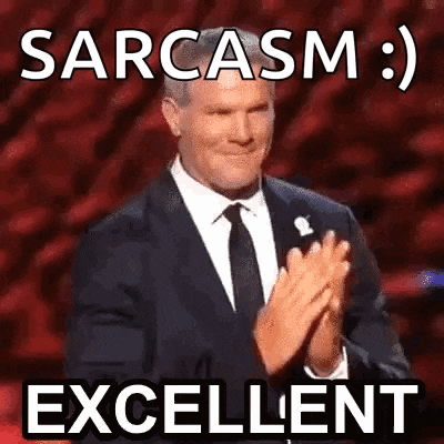 a man in a suit and tie is clapping his hands and saying sarcasm : excellent .