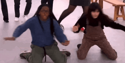 a man and a woman are kneeling down in front of a group of people .