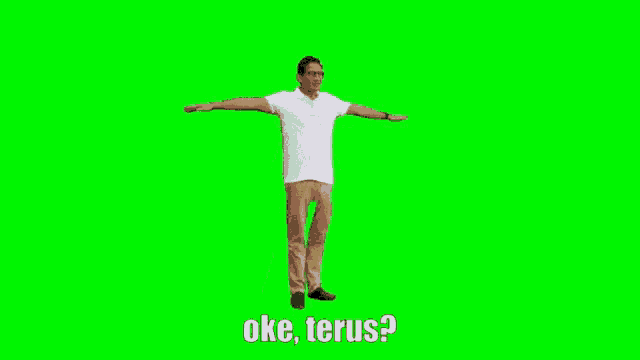 a man in a white shirt and khaki pants is standing on a green screen with his arms outstretched .