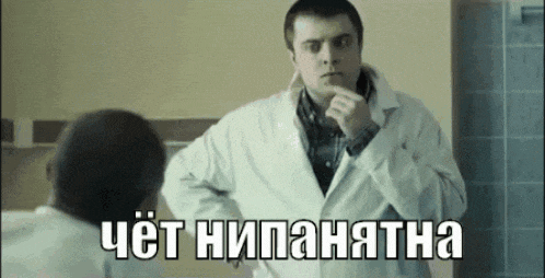 a man in a lab coat is looking at himself in the mirror and talking in a foreign language .