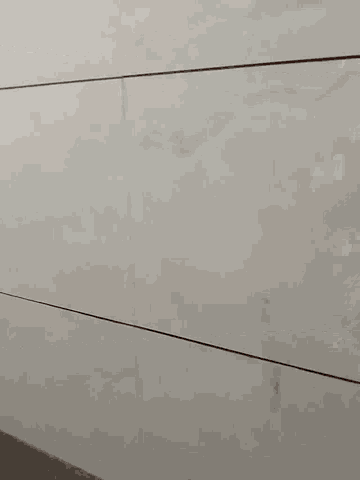 a close up of a white tile floor in a bathroom with a light shining through it .