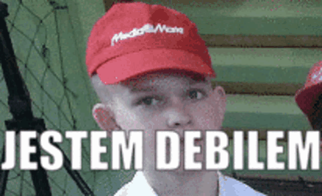 a boy wearing a red hat with the words jestem debilem on it