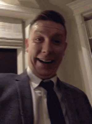 a man in a suit and tie is making a face