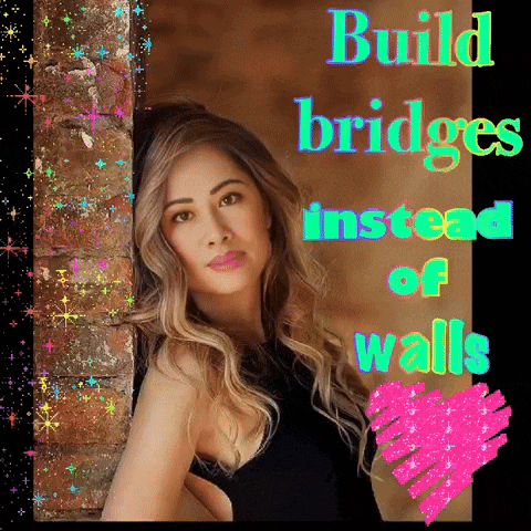 a woman leaning against a brick wall with the words " build bridges instead of walls " above her