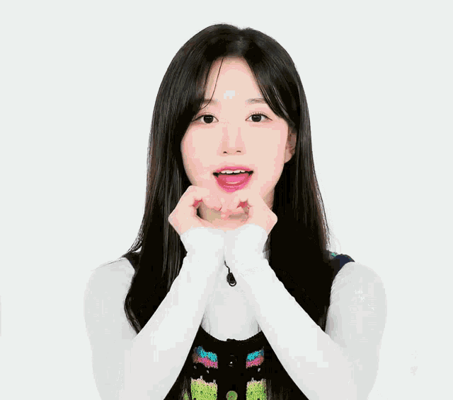 a girl is making a heart with her hands