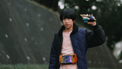 a man in a blue jacket is holding a sword