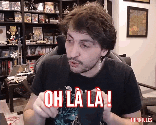 a man sitting in a chair with the words oh la la written on his shirt