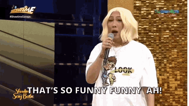a woman singing into a microphone with the words " that 's so funny funny ah " behind her