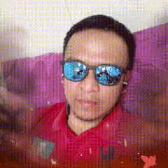 a man wearing sunglasses and a red shirt is laying on a purple couch