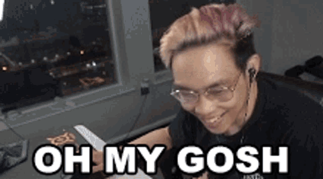 a man with glasses and pink hair is smiling and says oh my gosh .