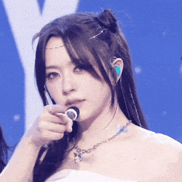 a close up of a woman 's face with a microphone in her mouth