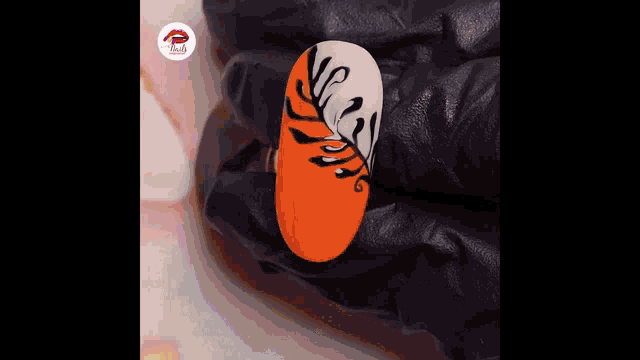 a close up of a person 's hand painting a nail with a brush .