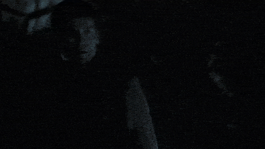 a man and a woman are kissing in a dark room
