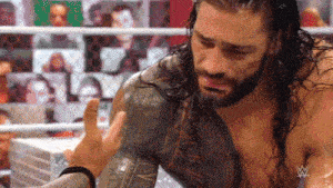 a man with long hair and a beard is crying in a wrestling ring