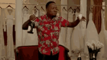 a man in a hawaiian shirt is holding a glass of champagne