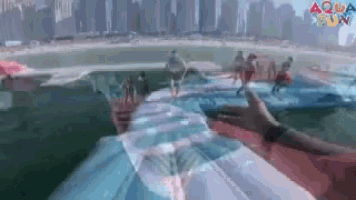 a person is swimming in a pool with a city in the background and the words aqua fun on the bottom