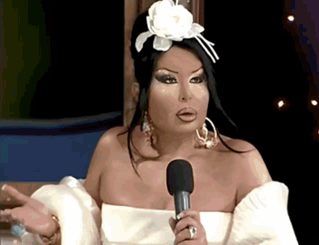 a woman in a white dress holds a microphone