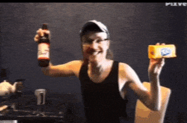 a man in a black tank top is holding a bottle of beer and a piece of cheese